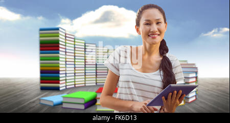 Composite image of businesswoman using tablet in the office Stock Photo