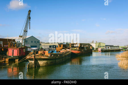 Dereliction including rusting iron river boats and machinery on the river Hull on a bright sunny morning in winter. Stock Photo