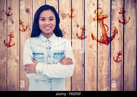 Composite image of asian woman with arms crossed smiling Stock Photo