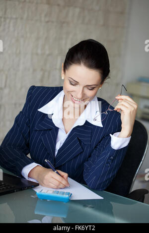 Happy accountant write on blank paper in office, teeth smile Stock Photo