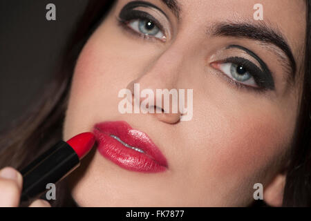 Woman applying red lipstick Stock Photo