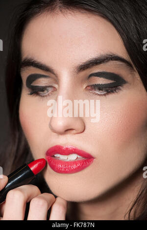 Woman applying red lipstick Stock Photo
