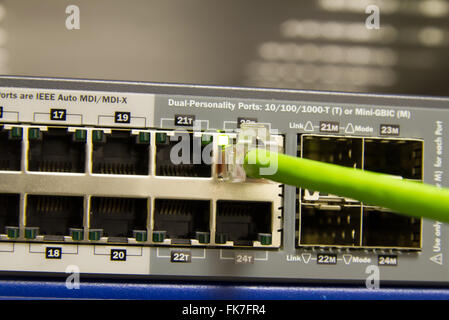 green ethernet cable plugged into server port Stock Photo