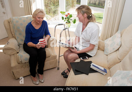 Nurse on a home visit completing a medical review with an elderly patient Stock Photo