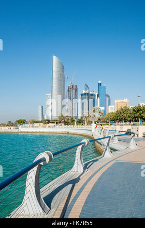 View along waterfront of Corniche towards modern office towers in Abu Dhabi United Arab Emirates Stock Photo