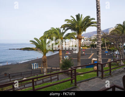 The beach of  Playa La Arena a resort town on the west coast of Tenerife. Black lava sand,  views of  the Atlantic ocean and  hotels Stock Photo