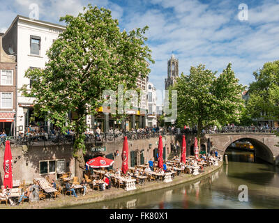 Dom Tower and people on outdoor terrace of restaurant along Oudegracht canal in the old city centre of Utrecht, Netherlands Stock Photo