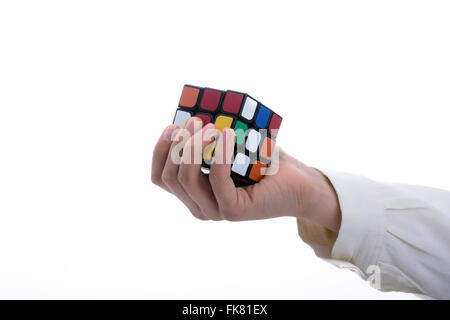 Child holding a Rubik's cube in hand on a white background Stock Photo