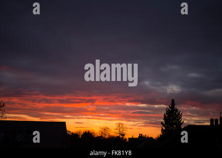Wimbledon, London, UK. 7th March, 2016. Clearing skies to the west of London allow the setting sun to glow on cloudbase, silhouetting suburban houses in the foreground. Credit:  Malcolm Park editorial/Alamy Live News