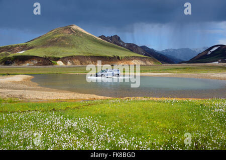 Volcanic landscape, Landmannalaugar, car driving through Joekugilskvisl glacial river, Fjallabak National Park, Iceland Stock Photo