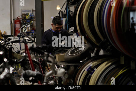 Mechanic repairing bikes in his workshop shop during Black Friday. In one day open and very crowed Stock Photo