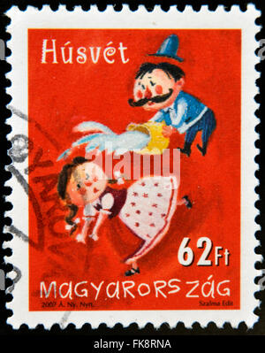 HUNGARY - CIRCA 2007: A stamp printed in Hungary dedicated to Easter, shows a man pouring water a girl, circa 2007 Stock Photo