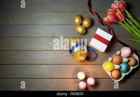 Easter eggs and lit candles wooden background Stock Photo