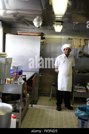 Ship's cook chef poses for photo in Utrillo Container Ship galley. Stock Photo