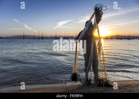 Fisherman in Santo Antonio de Lisboa beach at sunset Stock Photo