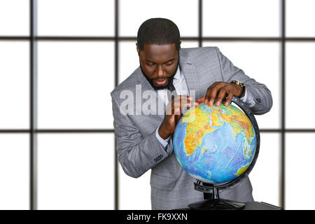 Afroamerican with globe in office. Stock Photo