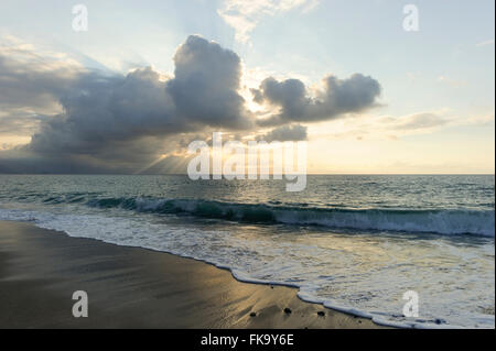 Ocean sun rays is brightly light golden seascape with waves rolling to the shore as scattered sunbeam break through a dramatical Stock Photo