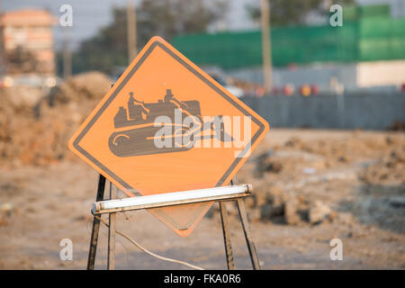 warning sign of construction vehicles on the road Stock Photo