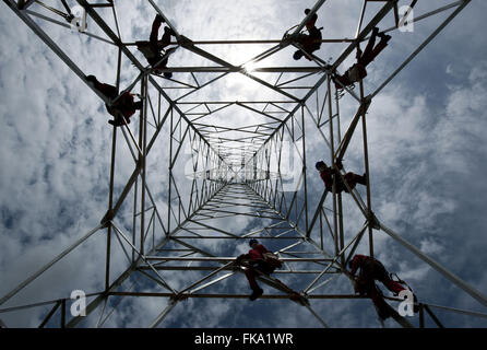 Workmen fixing tower for power transmission line Stock Photo