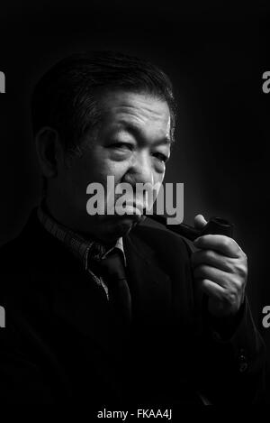 Senior man smoking a pipe Stock Photo