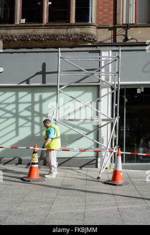 Scaffolding for painting outside a shop. Stock Photo