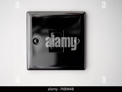 Black house hold light switch on a white wall Stock Photo