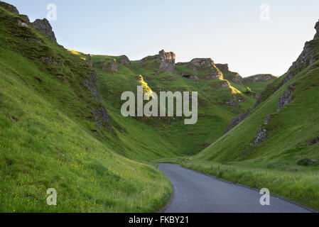 Winnats Pass near Castleton in the Peak District, Derbyshire. Steep green hillside rise up from the road. Stock Photo