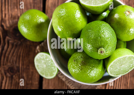 Limes on vintage wooden background (close-up shot) Stock Photo