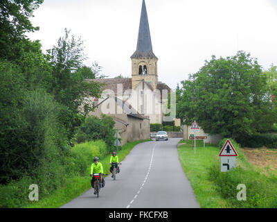 Two touring cyclists riding their bikes on a country road. Stock Photo