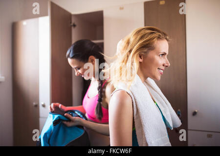 Two woman changing in locker room in gym Stock Photo