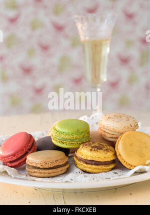 Macaroons on plate with champagne in background Stock Photo