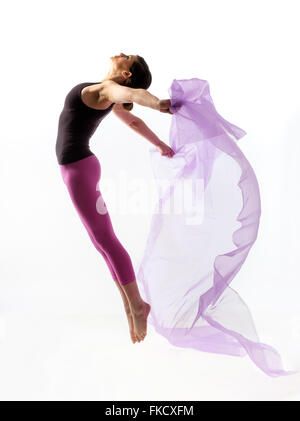 Woman with sheer fabric jumping Stock Photo