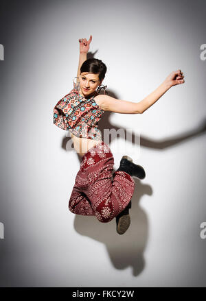 Young woman jumping against white background Stock Photo - Alamy