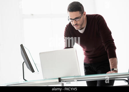 Man using laptop in office Stock Photo
