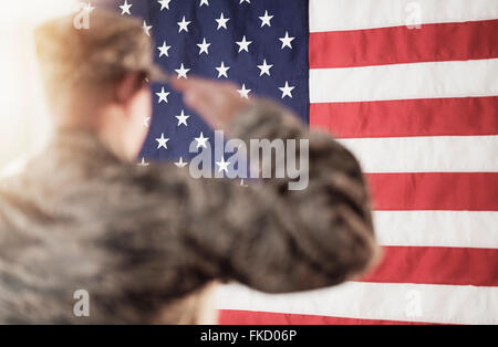 Soldier saluting American flag Stock Photo