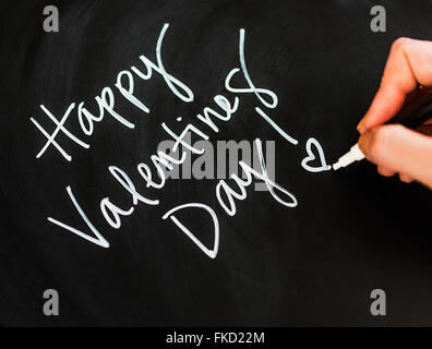 Man's hand writing on black paper Stock Photo