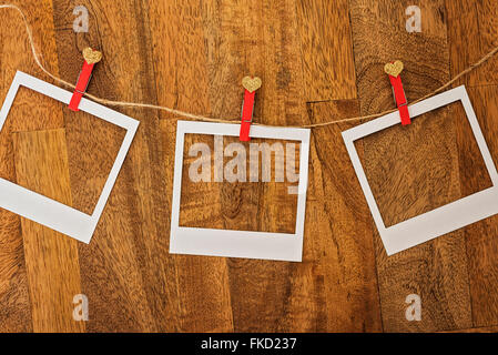 Empty Polaroid frames in a row on wood Stock Photo