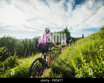Family with children ( 10-11, 12-13) cycling in mountains Stock Photo