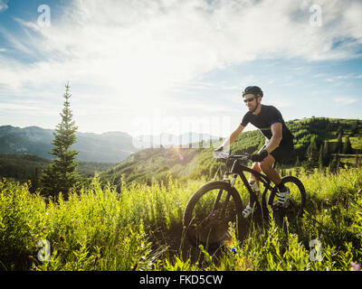 Man during bicycle trip in mountain scenery Stock Photo