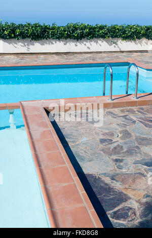 empty swimming pool with ivy on wall and blue sky Stock Photo