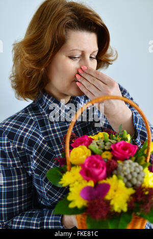 woman with allergic rhinitis is holding a bouquet of flowers Stock Photo