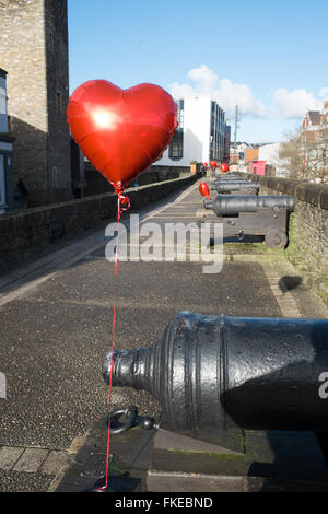 Red balloons tied to the cannons on Derry City Walls Derry Londonderry Northern Ireland Stock Photo