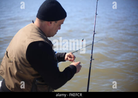 Fisherman baiting hook Stock Photo