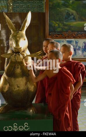 Young monks at golden rabbit, Soon U Ponya Shin Paya Pagoda, Sagaing Hill, Myanmar Stock Photo