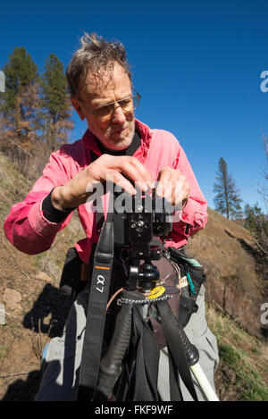 Backpacker taking a picture using a makeshift tripod in Northeast Oregon's Wenaha River canyon. Stock Photo