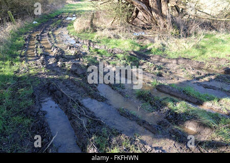 flooded and deeply rutted footpath Stock Photo