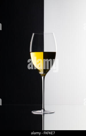 Single glass of wine  isolated on black and white background and glass desk Stock Photo