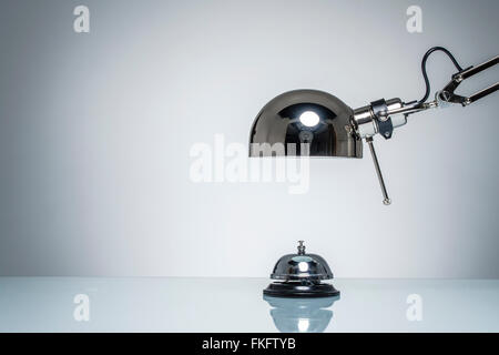 lighting up hotel bell for calling service with desk lamp on round studio lighting Stock Photo