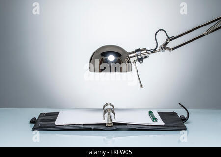 lighting up notebook diary writing with desk lamp on round studio lighting Stock Photo