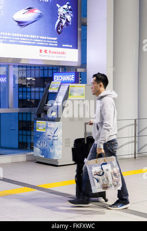 A man walks past a automated currency exchange machine inside the Haneda Airport International Terminal Station on March 9, 2016, Tokyo, Japan. To provide better services for an increasing number of international travelers, Shinagawa Ward in collaboration with JTB Business Innovation Corp. provides two automated currency exchange machines at Tokyo Monorail's Haneda Airport Station. The machines have menus in English, Korean, Chinese and Japanese, and allow users to exchange multiple currencies in both directions. © Rodrigo Reyes Marin/AFLO/Alamy Live News Stock Photo